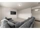 Bright living room features a large gray sectional sofa and a mounted flatscreen television at 3317 Sweetleaf Ln, Buford, GA 30519