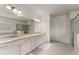 Bathroom featuring double sinks, soaking tub, glass-enclosed shower, and neutral tile flooring at 3317 Sweetleaf Ln, Buford, GA 30519