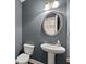 Stylish powder room with elegant pedestal sink, decorative mirror, and modern lighting fixtures at 3317 Sweetleaf Ln, Buford, GA 30519