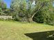 Large grassy backyard with a mature tree on a sunny day at 5286 Joan Of Arc Pl, Atlanta, GA 30349