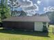 Rear exterior view of a single-story brick and siding home with fenced-in yard and boarded up windows at 5286 Joan Of Arc Pl, Atlanta, GA 30349