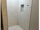 A shower with white marble tiling and a soap niche, complemented by a classic tile floor at 743 San Fernando Se Dr, Smyrna, GA 30080