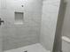 A modern shower with white marble-style tiles, accented with a stylish mosaic tile inset at 743 San Fernando Se Dr, Smyrna, GA 30080