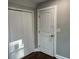 Hallway showcasing neutral paint, classic baseboards, closet with door ajar, and a white door at 743 San Fernando Se Dr, Smyrna, GA 30080