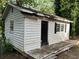 Rustic shed featuring weathered wood, a dark door, and a small deck, offering potential for storage or a creative space at 1978 Winding Creek Sw Ln, Marietta, GA 30064