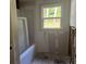 Bathroom shows a new bathtub insert and a window that offers natural light to the space at 3831 Dillard St, Powder Springs, GA 30127