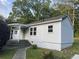 Rear exterior view of the home showing the entrance, light-colored siding, and surrounding yard at 3831 Dillard St, Powder Springs, GA 30127