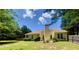View of a home's backyard featuring a yellow house and plenty of shade at 4801 Devonhurst Way, Powder Springs, GA 30127