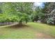 Backyard featuring spacious lawn and tall mature trees, perfect for outdoor activities at 4801 Devonhurst Way, Powder Springs, GA 30127
