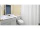 Bathroom with white vanity, toilet, and shower with white shower curtain at 4801 Devonhurst Way, Powder Springs, GA 30127