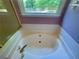 This bathroom features a soaking tub with a large window that provides natural light at 4801 Devonhurst Way, Powder Springs, GA 30127