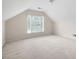 Spacious bonus room featuring carpet, neutral paint, and window with natural light at 4801 Devonhurst Way, Powder Springs, GA 30127