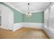 Formal dining room with wainscoting, hardwood floors, and modern chandelier at 4801 Devonhurst Way, Powder Springs, GA 30127
