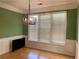 Cozy dining room featuring wainscoting, a modern chandelier, and large windows at 4801 Devonhurst Way, Powder Springs, GA 30127