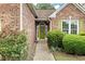 Close-up of the green front door with decorative glass and manicured landscaping at 4801 Devonhurst Way, Powder Springs, GA 30127