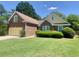 Beautiful brick home showcasing a lush green lawn, mature landscaping, and a welcoming facade at 4801 Devonhurst Way, Powder Springs, GA 30127