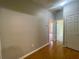 Neutral hallway featuring hardwood floors and multiple entryways to other rooms at 4801 Devonhurst Way, Powder Springs, GA 30127