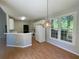 Eat-in kitchen features white appliances, a peninsula counter, and natural light at 4801 Devonhurst Way, Powder Springs, GA 30127