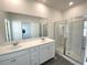 Modern bathroom featuring double sinks, a large mirror, and a glass-enclosed shower at 741 Cordele Ln, Sugar Hill, GA 30518