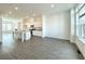 Open-concept living room and kitchen area with grey wood floors, a kitchen island, and natural light at 741 Cordele Ln, Sugar Hill, GA 30518