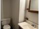 Bathroom features a toilet, a wood cabinet sink and framed mirror at 816 Cedar Lake Se Dr, Conyers, GA 30094