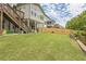 Expansive backyard featuring a lush lawn, a wooden fence, and a covered patio for outdoor enjoyment at 935 Grove Valley Drive Dr, Cumming, GA 30041