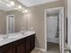 Bathroom showcasing double vanity and shower-over-tub through doorway at 935 Grove Valley Drive Dr, Cumming, GA 30041
