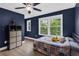 Bedroom with navy walls, ceiling fan, and view of backyard at 935 Grove Valley Drive Dr, Cumming, GA 30041