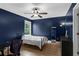 Bedroom with navy walls, ceiling fan, desk, and closet at 935 Grove Valley Drive Dr, Cumming, GA 30041