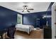 Cozy bedroom with dark blue walls, hardwood floors, and a window view at 935 Grove Valley Drive Dr, Cumming, GA 30041