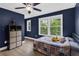 Comfortable bedroom featuring large windows, dark blue walls, and hardwood floors at 935 Grove Valley Drive Dr, Cumming, GA 30041