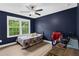 Bedroom with navy walls, ceiling fan, and view of backyard at 935 Grove Valley Drive Dr, Cumming, GA 30041