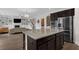 Open kitchen with island, granite counters, dark cabinets, and stainless appliances at 935 Grove Valley Drive Dr, Cumming, GA 30041