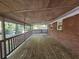 Large covered back porch area with brick siding, railings, and wooden floors at 1150 Goldsmith Rd, Stone Mountain, GA 30083
