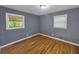 Cozy bedroom featuring two windows for ample natural light and classic hardwood floors at 1150 Goldsmith Rd, Stone Mountain, GA 30083