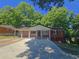 Charming brick home featuring a covered front porch with classic column detailing and a wide driveway at 1150 Goldsmith Rd, Stone Mountain, GA 30083