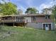 Backyard view featuring a brick home, wooden deck, and partially overgrown lawn at 2039 Harwinor Se Rd, Smyrna, GA 30082