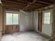 This unfinished room features wood studs, a new window and a door at 2039 Harwinor Se Rd, Smyrna, GA 30082