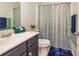 Clean bathroom features a vanity sink, toilet, and a blue and green shower curtain at 2689 Muskeg Sw Ct, Atlanta, GA 30331