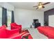 Bedroom with ceiling fan, television, bright red chairs and carpet at 2689 Muskeg Sw Ct, Atlanta, GA 30331