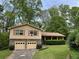 Split level home with neutral siding, garage, stone accents, and mature trees at 3511 Brookview Dr, Marietta, GA 30068