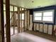 A bedroom featuring exposed studs and insulation, and hardwood floors with a blue accent wall at 644 Cambridge Dr, Marietta, GA 30066