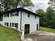 Side view of a two-story home featuring access doors to the basement and a curved brick retaining wall at 644 Cambridge Dr, Marietta, GA 30066