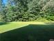 Spacious backyard with lush green grass and mature trees providing shade at 311 Arbor Point Sw Ct, Lilburn, GA 30047