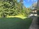 Expansive backyard featuring lush lawn and mature trees, perfect for outdoor activities and relaxation at 311 Arbor Point Sw Ct, Lilburn, GA 30047