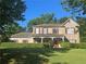 Traditional brick home with a manicured lawn, red shutters, and covered front porch entrance at 311 Arbor Point Sw Ct, Lilburn, GA 30047