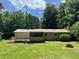 Home's backyard with a deck, large lawn, and mature trees at 6512 Executive Dr, Winston, GA 30187