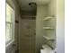 Bathroom featuring a shower, window, floating shelves, toilet, and sink at 6512 Executive Dr, Winston, GA 30187