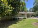 Charming home featuring a covered carport and a cozy front porch surrounded by lush greenery at 6512 Executive Dr, Winston, GA 30187