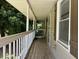 View of the long covered front porch with railing extending from the front door at 6512 Executive Dr, Winston, GA 30187